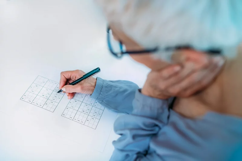 elder woman working on sudoku puzzle