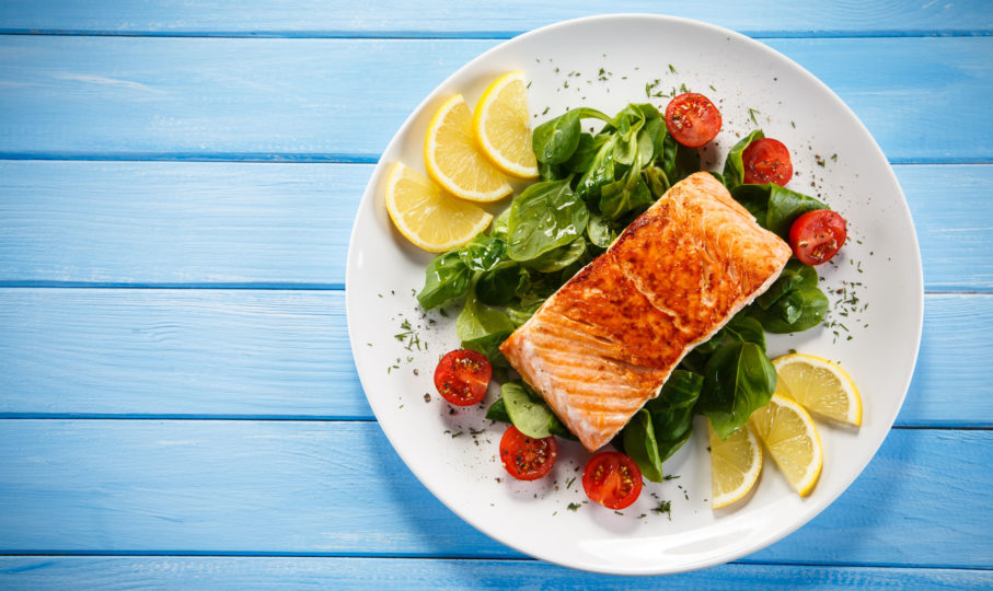 Plate of spinach salmon lemon tomatoes